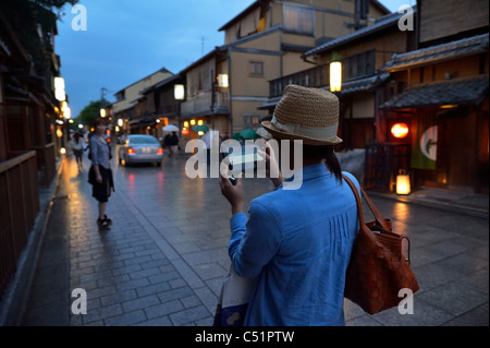 Un touriste japonais est la navigation dans le district de Gion traditionnel par le biais d'applications Blackberry Playbook, Kyoto, Japon JP Banque D'Images