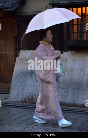 Une Geisha japonaise (Geiko) marchant le long des restaurants traditionnels dans le quartier historique de Gion, Kyoto, Japon JP Banque D'Images