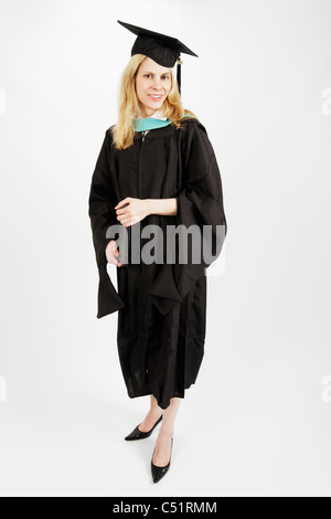 Jeune femme vêtue de Graduation Gown Holding, du certificat d'études supérieures et Smiling Banque D'Images