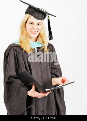 Vue rapprochée d'un diplômé en tenue de cérémonie Certificat Holding Banque D'Images