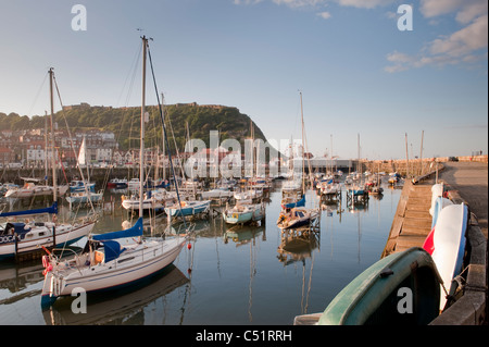 Port extérieur de Scarborough, moorings artisanaux (yachts et bateaux amarrés au soleil du soir) et promontoire du château - pittoresque North Yorkshire Coast, Angleterre, Royaume-Uni Banque D'Images