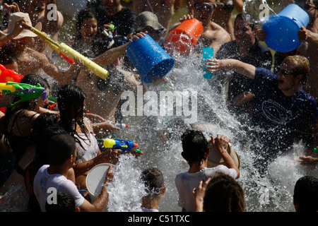 Les jeunes fêtards juifs spry sur l'eau les uns les autres au cours de l'eau annuel lutte en Rabin Square centre-ville de Tel Aviv ISRAËL Banque D'Images