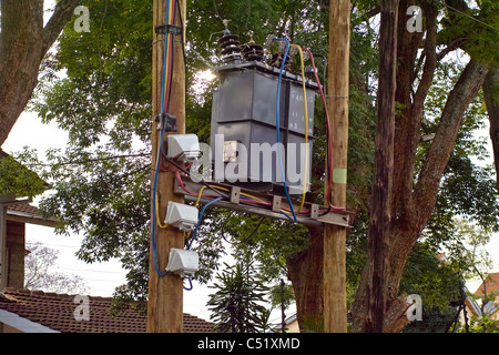 Un transformateur d'électricité monté au-dessus du sol sur des poteaux en bois Banque D'Images