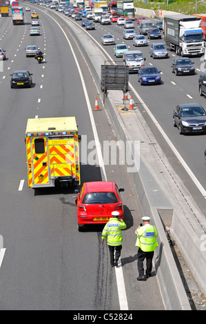 Vue aérienne la police de la circulation inspectant la voiture impliquée dans un accident de la route comprend une ambulance stationnaire (note des marques de dérapage) autoroute M25 Essex Angleterre Royaume-Uni Banque D'Images