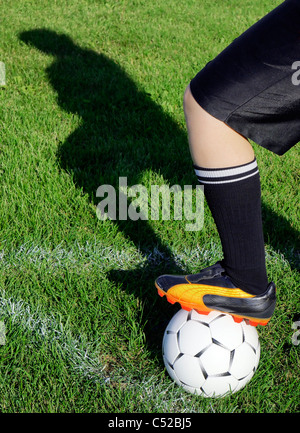 Joueur de football ou soccer en attendant le signal pour donner un coup de boule d'angle à l'angle avec silhouette de l'ombre sur l'herbe sur le terrain. Banque D'Images