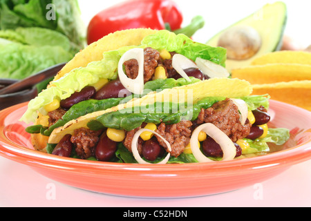 Tacos mexicains avec du boeuf haché, de la laitue, des haricots rouges et de maïs sur un fond blanc Banque D'Images