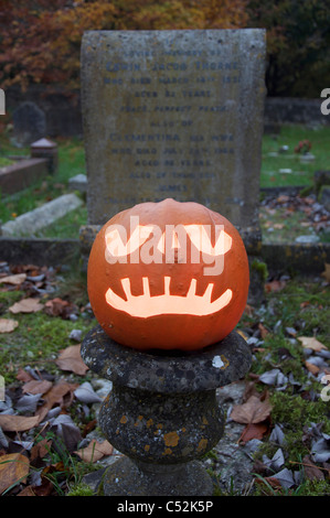 Un Halloween Jack O' Lantern taillée dans une citrouille, ardent à la chandelle, dans un vieux cimetière. Angleterre, Royaume-Uni. Banque D'Images