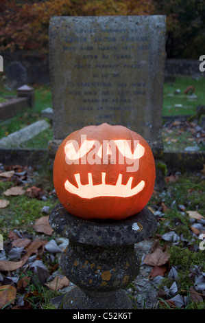 Un Halloween Jack O' Lantern taillée dans une citrouille, ardent à la chandelle, dans un vieux cimetière. Angleterre, Royaume-Uni. Banque D'Images