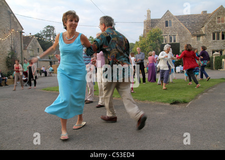 PEPLE LA DANSE À LA MUSIQUE FOLKLORIQUE TRADITIONNELLE ANGLAISE DANS UN CEILIDH AU FARM dans le Somerset, England, UK Banque D'Images