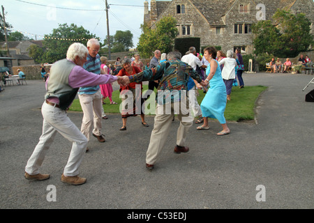 PEPLE LA DANSE À LA MUSIQUE FOLKLORIQUE TRADITIONNELLE ANGLAISE DANS UN CEILIDH AU FARM dans le Somerset, England, UK Banque D'Images