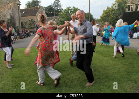 PEPLE LA DANSE À LA MUSIQUE FOLKLORIQUE TRADITIONNELLE ANGLAISE DANS UN CEILIDH AU FARM dans le Somerset, England, UK Banque D'Images