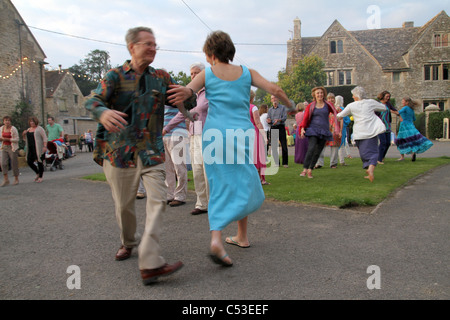 PEPLE LA DANSE À LA MUSIQUE FOLKLORIQUE TRADITIONNELLE ANGLAISE DANS UN CEILIDH AU FARM dans le Somerset, England, UK Banque D'Images