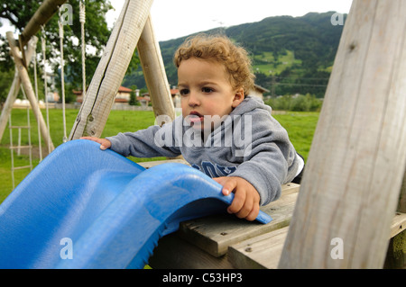 Jeune enfant de deux pièces sur une diapositive dans une aire photographié en Autriche Banque D'Images