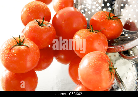Les tomates fraîches sur le miroir avec tamis Banque D'Images
