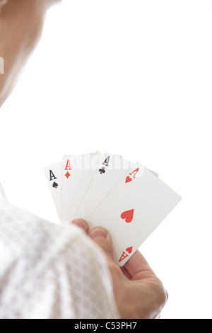 Man holding avec quatre cartes d'as. Vue arrière sur un fond blanc. L'accent est sur les cartes Banque D'Images