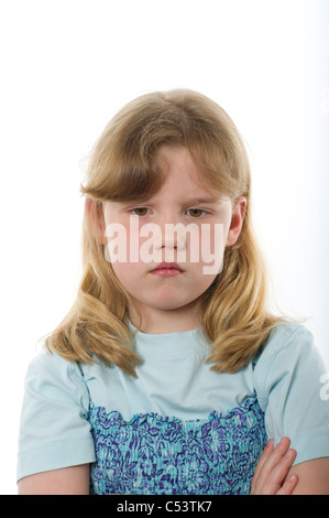 Jeune fille de l'âge primaire à la colère ou malheureuse contre l'arrière-plan blanc uni studio. Banque D'Images