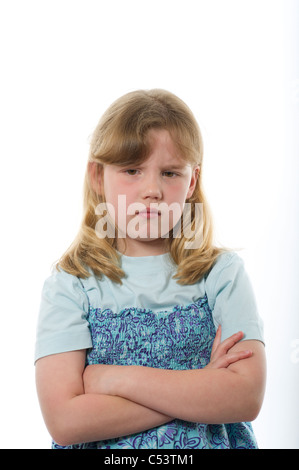 Jeune fille de l'âge primaire à la colère ou malheureuse contre l'arrière-plan blanc uni studio. Banque D'Images