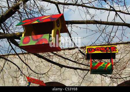 Deux cabanes en bois coloré / colorés se suspendre à un arbre sans feuilles. Banque D'Images