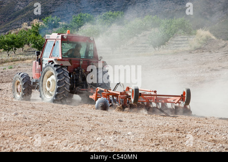 Un agriculteur labourant le sol poussiéreux sec près de Lorca, Murcia, Espagne. Banque D'Images