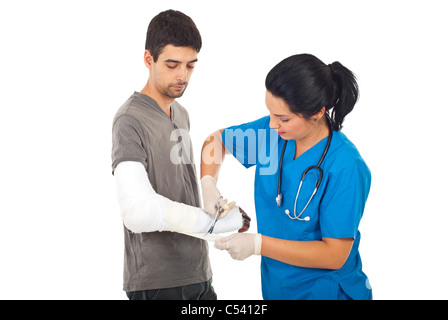 Femme médecin et à l'aide de ciseaux à bandage main blessée homme isolé sur fond blanc Banque D'Images