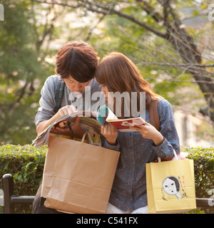 Couple un magazine dans un parc, Teapot Lane, Kyoto, Japon Banque D'Images