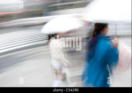 Image floue de deux femmes marchant avec parasols dans une rue, Ginza, Chuo Ward, Tokyo, Japon Banque D'Images