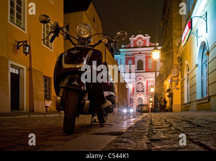 Magnus A Moto Scooter dans une rue le soir, Poznan, Pologne Banque D'Images