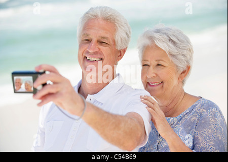 Happy senior couple de prendre une photo d'eux-mêmes avec un appareil photo numérique Banque D'Images