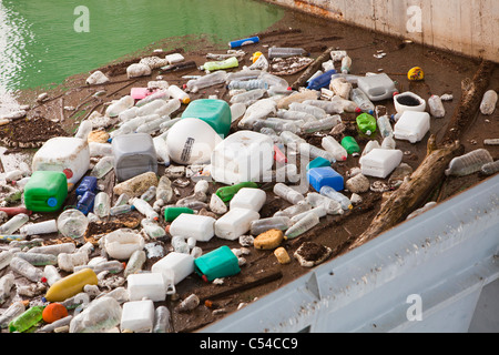 Déchets en plastique flottant contre le mur de barrage de l'Iznajar hydro electric power station à proximité d'Antequera en Andalousie, espagne. Banque D'Images