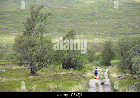 Un marcheur sur la piste à partir de réservoir de Blackwater à Kinlochleven dans les Highlands écossais. Banque D'Images