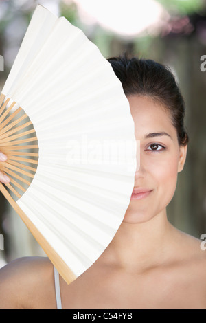 Belle Jeune femme tenant un ventilateur chinois en face de son visage Banque D'Images