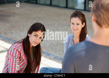 Homme debout en face de deux femmes Banque D'Images