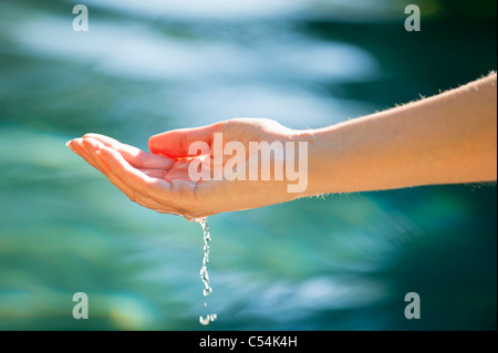 Close-up de la main d'un homme toucher l'eau de la piscine Banque D'Images