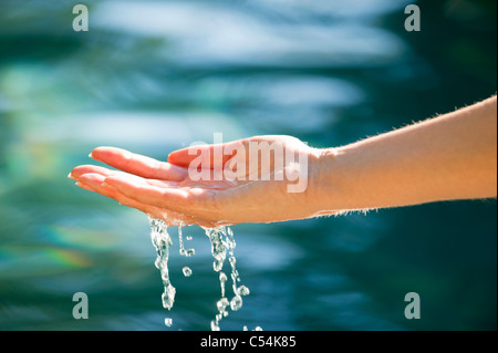 Close-up de la main d'un homme toucher l'eau de la piscine Banque D'Images