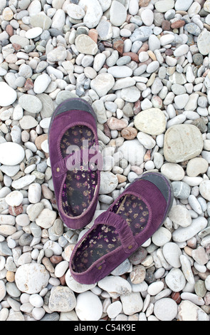 Chaussures femme allongée sur la plage des pierres Banque D'Images