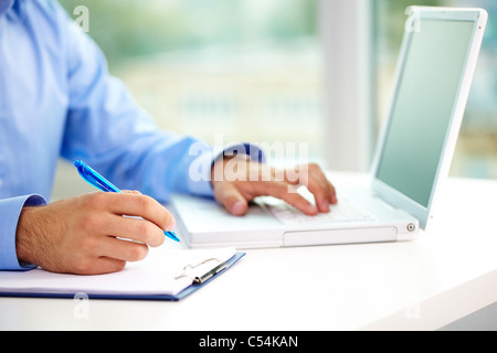 Close-up of businessman hands typing et prendre des notes Banque D'Images
