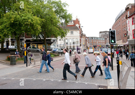 Les personnes qui franchissent un passage pour piétons alors que les feux de circulation sont toujours en vert dans le centre-ville de Norwich, en Angleterre. Banque D'Images