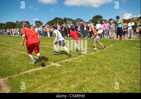 Les jeunes garçons petite course à la rencontre annuelle des sports le jour à une petite école primaire, UK Banque D'Images