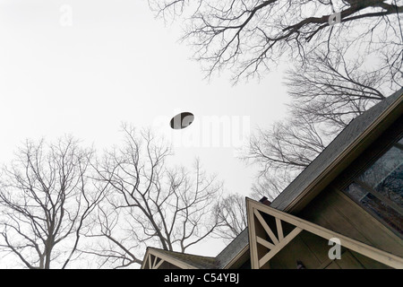 Ovni survolant une maison. Banque D'Images