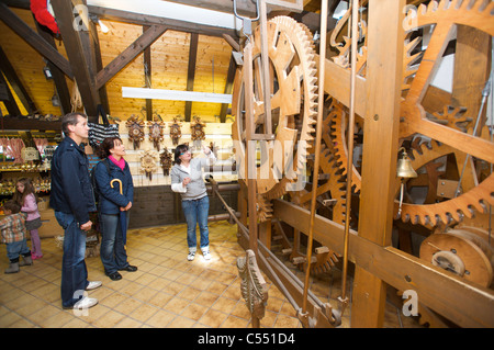 Femme expliquant les mécanismes de la plus grande horloge de coucou, Schönwald dans la Schwarzwald, Baden-Wurttemberg, Allemagne Banque D'Images