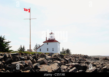 Drapeau canadien près d'un phare, le phare de Gilbert's Cove, baie de Fundy, en Nouvelle-Écosse, Canada Banque D'Images