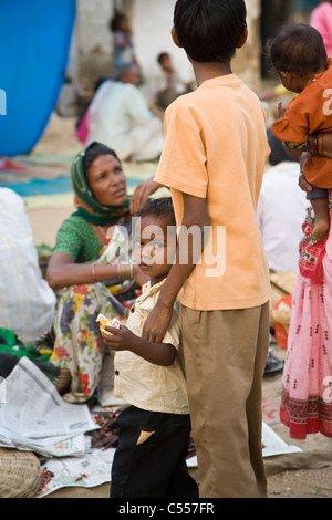 Indien de l'enfant avec le frère et la mère, à la cause, tout en shopping en famille dans Kanha village market dans l'Inde rurale Banque D'Images