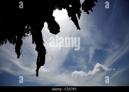 Silhouette de stalactites contre un ciel bleu avec des nuages dans les îles de Phang Nga, Phuket, Thailand Banque D'Images