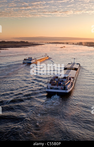 Les Pays-Bas, Nijmegen, bateaux cargo sur la rivière Waal. Le lever du soleil. Banque D'Images