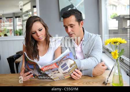 Jeune couple cherche à acheter ou louer un bien immobilier parcourir Dernières Homes property à Brighton UK Banque D'Images