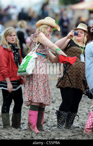 Les filles d'attente dans la boue au festival de Glastonbury 2011 Banque D'Images