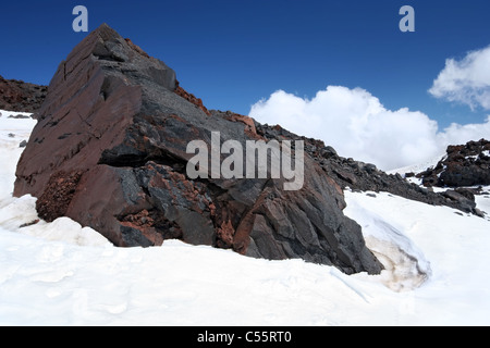 Énorme rocher (pierre) entre la neige à la pente de la crête l'Elbrous. Caucase. La Russie. Banque D'Images