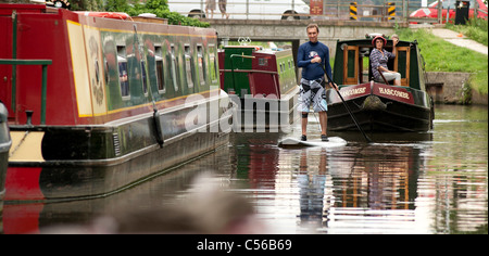 Les gens s'amusant sur la rivière Wey Navigations près de GODALMING Surrey, UK. Un homme walkboarding sur l'animée river. Banque D'Images