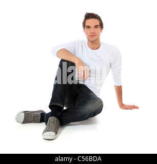 Beau jeune homme assis. Le tout sur fond blanc. Banque D'Images