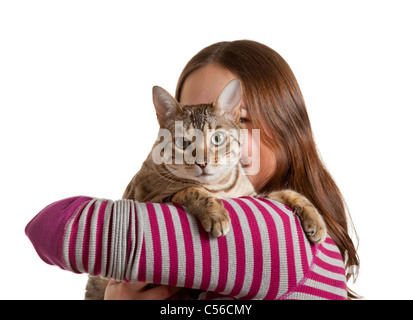 Bengal chat est assis sur l'épaulement de la jeune femme et regarde dans la caméra studio shot isolés montrant l'amour entre l'animal et le propriétaire Banque D'Images